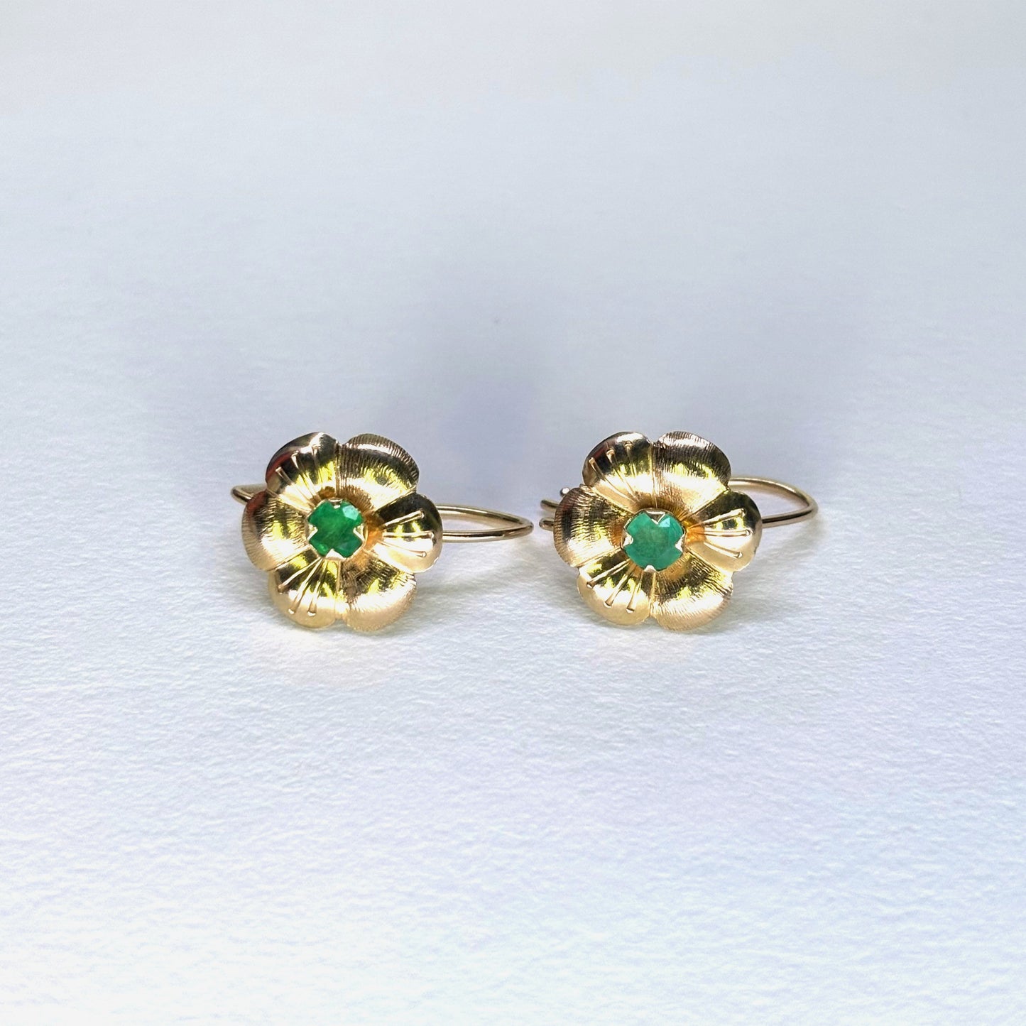 Aretes en forma de flor de oro de 18k con esmeraldas naturales colombianas