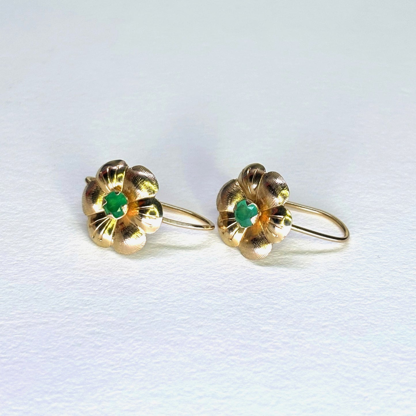 Aretes en forma de flor de oro de 18k con esmeraldas naturales colombianas
